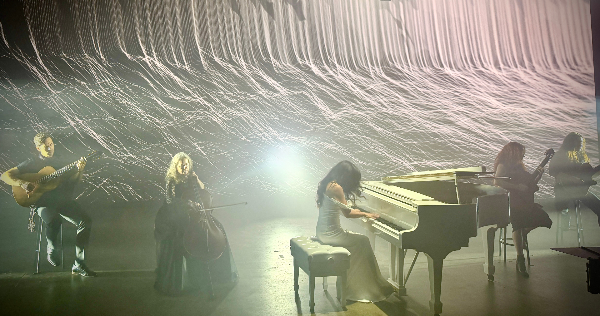 Six String Symphony performing live on stage with classical guitar, cello, piano and violin